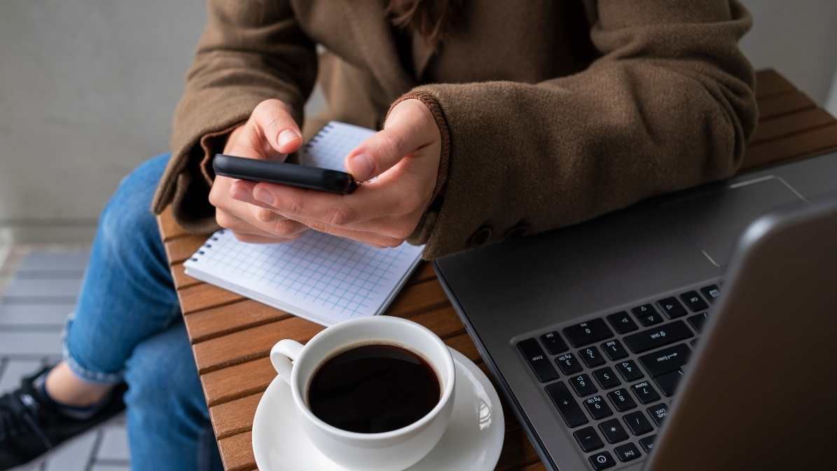 Mujer joven revisando su celular con fondo pastel azul y gráficos de conectividad, representando el crecimiento de los planes pospago en México.